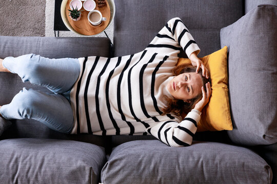 Top view depressed young woman lying on sofa