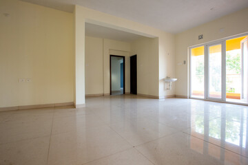 Unfurnished new living room in wide angle. Vast sliding doors which gives light. Sun-lighted living room