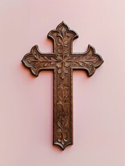  Ornate carved. wooden cross. Christian. Christ. Holy. Religious. Symbol. Church. Faith. Pink background.
