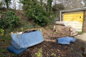 Abandoned and Dumped Sofa Armchair at the Garages Flytipped in the Rain