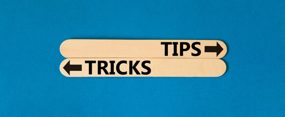 Tips and tricks symbol. Concept word Tips and tricks on beautiful wooden stick. Beautiful blue...
