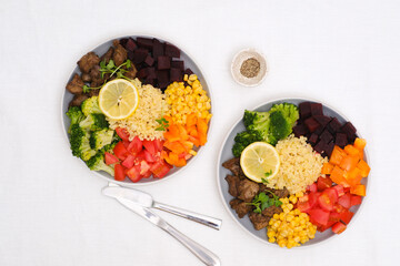 Bowl dish with fried turkey liver, bulgur, beet, pepper, tomato, broccoli, sweet corn, lemon. Healthy balanced eating. Top view