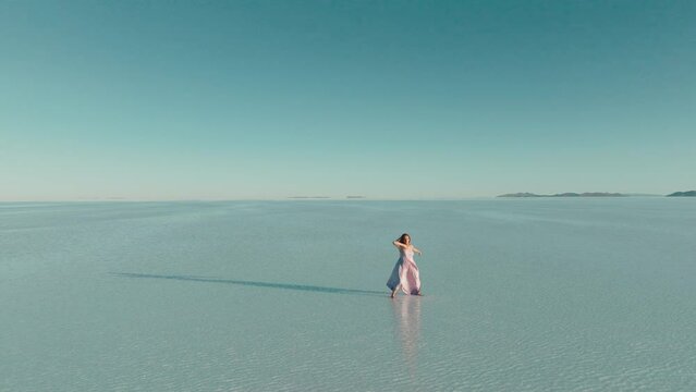 Drone view of Salt Flats of Bolivia and a redhead dancer performing