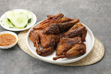 Ayam Bakar, roasted chicken with herbs and spice. Served with chilli paste and cucumber. Indonesian...