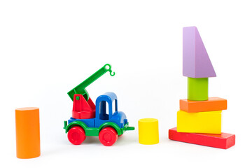 Children's toys, multi-colored car, wooden constructor cubes on a white background.