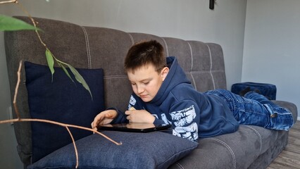 Child deeply engrossed in tablet gaming exploring digital realms Immersed in game he navigate...