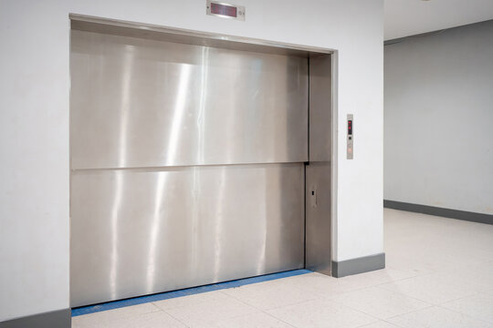 Modern freight elevator featuring a sleek two-section slide-up door design