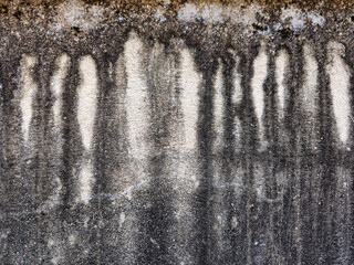 The surface of the house's cement wall has long-lasting algae stains from the rain that has fallen...