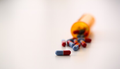 Tablets scattered blue and red color jar on the table of pharmaceutical laboratory pill for the prescription and treatment various diseases chemistry
