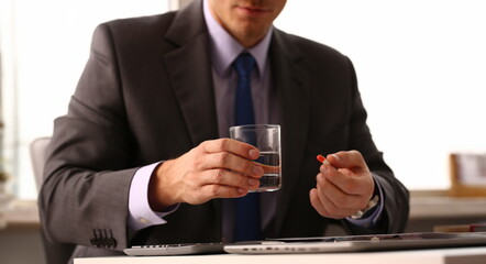 Adult male businessman hold tablet on glass water. On January 1 after celebrating the new year came to work while intoxicated closeup concept