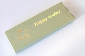 A box of chocolate eggs with the inscription in English Happy Easter.