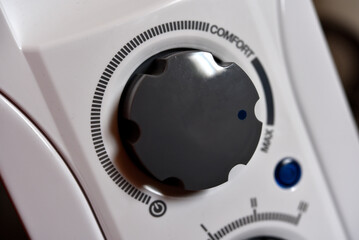Round switches on a white radiator. The control panel.