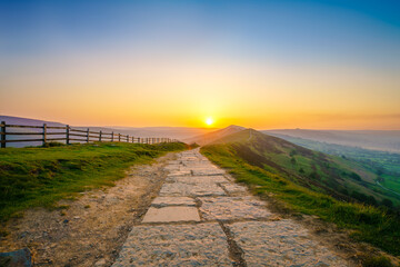 Stone footpath and wooden fence leading a long The Great Ridge in the English Peak District - 778255261