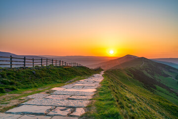 Stone footpath and wooden fence leading a long The Great Ridge in the English Peak District - 778263424