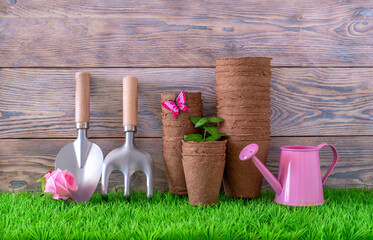 Biodegradable peat pots for seedlings and garden tools. Zero waste. Wooden beige background. Taking...