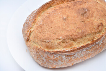 A fresh loaf of bread on a plate.  A piece of delicious bread. Bakery products.