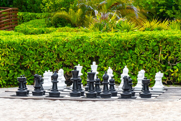Giant large chess pieces on chessboard outside on beach Mexico.
