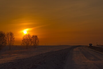 Russia, Southern Kuzbass. Colorful picturesque sunrise on a frosty morning in snow-covered fields.