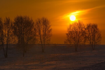 Russia, Southern Kuzbass. Colorful picturesque sunrise on a frosty morning in snow-covered fields.