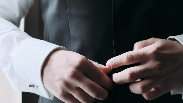 businessman buttons his tailcoat close-up of hands