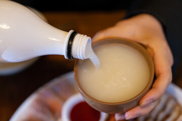 pouring makgeolli, Korean rice wine into the cup