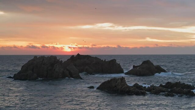 Beautiful sunrise sky on the rocky coastline of the sea
