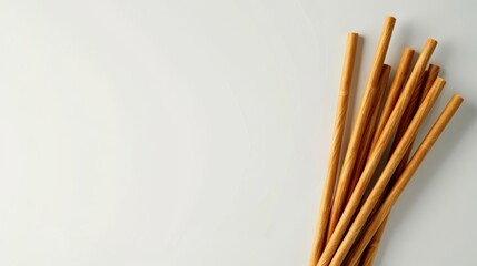Eco-friendly reusable wooden straws on a minimalist white background