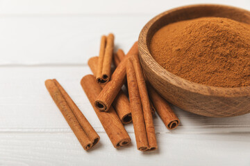 Cinnamon sticks on a textured wooden background. Cinnamon roll. Spicy spice for baking, desserts and drinks. Fragrant ground cinnamon. cinnamon powder Close-up. Place for text. copy space