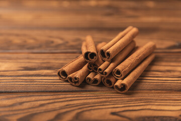 Cinnamon sticks on a textured wooden background. Cinnamon roll. Spicy spice for baking, desserts and drinks. Fragrant ground cinnamon. cinnamon powder Close-up. Place for text. copy space