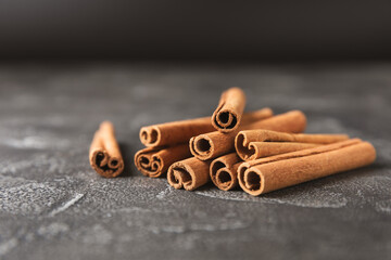 Cinnamon sticks on a textured wooden background. Cinnamon roll. Spicy spice for baking, desserts and drinks. Fragrant ground cinnamon. cinnamon powder Close-up. Place for text. copy space