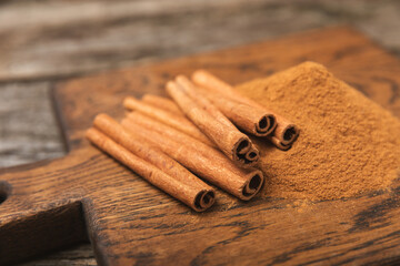 Cinnamon sticks on a textured wooden background. Cinnamon roll. Spicy spice for baking, desserts and drinks. Fragrant ground cinnamon. cinnamon powder Close-up. Place for text. copy space