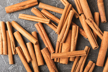 Cinnamon sticks on a textured wooden background. Cinnamon roll. Spicy spice for baking, desserts and drinks. Fragrant ground cinnamon. cinnamon powder Close-up. Place for text. copy space