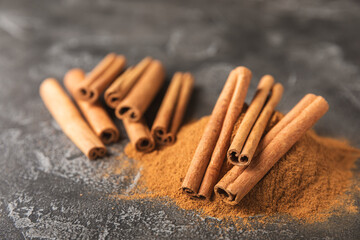 Cinnamon sticks on a textured wooden background. Cinnamon roll. Spicy spice for baking, desserts and drinks. Fragrant ground cinnamon. cinnamon powder Close-up. Place for text. copy space