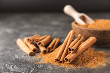 Cinnamon sticks on a textured wooden background. Cinnamon roll. Spicy spice for baking, desserts and drinks. Fragrant ground cinnamon. cinnamon powder Close-up. Place for text. copy space