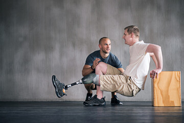 Trainer, person with a disability and prosthetic leg and dumbbell in physiotherapy, studio and gym ball. Male people, physiotherapist and amputee for wellness, fitness and exercise in sports center