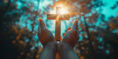 Fotobehang Silhouette of hands holding cross, praying for salvation, forgiveness, under sunlight, praising faith in Jesus Christ. © Andrii Zastrozhnov