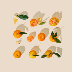 Fresh juicy orange yellow tangerines as minimal flat lay square pattern, Citrus oranges fruits with green leaves on beige background. Still life geometric layout of mandarin, summer card