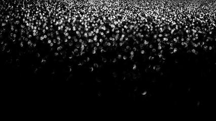 Bokeh lights on black background, shot of flying drops of water in the air, defocused water drops levitation on dark, blurred.