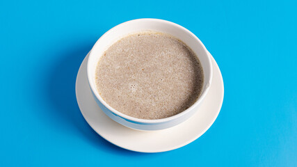 Mushrooms soup bowl top view isolated on blue