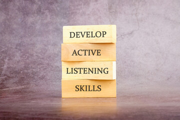 Concept word Develop active listening skills on wooden blocks. The concept of a business idea