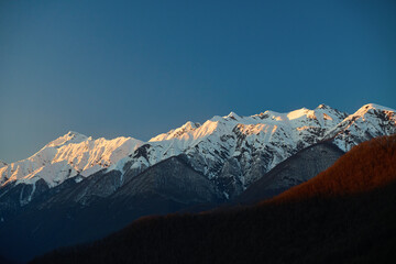 Sunset Alpenglow on Snowy Mountain Peaks - 778320619