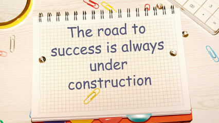 The road to success is always under construction text the phrase is written on a notebook in a cage - obrazy, fototapety, plakaty
