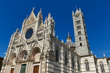 Fototapeta na wymiar La façade et le campanile de la cathédrale Santa Maria Assunta à Sienne 