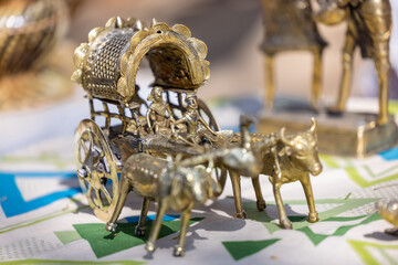 A handmade brass idol of indian farmer riding on bull cart is a stunning piece of art that blends craftsmanship with nature significance. - obrazy, fototapety, plakaty
