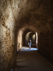 Underground tunnel at the Roman Theatre of Cádiz with a young woman in sundress walking through
