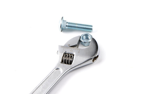 An adjustable wrench with a bright steel or stainless steel hex carriage bolt and hex nut isolated on white