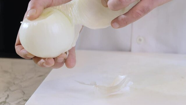 Close-up of a chef peeling white onion. 4k slow motion 100fps video.