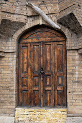 Old locked wooden door in vintage wall, vertical picture - 778339826