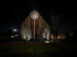 Parish of the Most Holy Body and Blood of Christ in Czestochowa, Poland. View of the church from the outside at night. "The Unity of the Cross and the Eucharist"