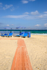 Sunbeds with umbrella on sandy beach of Marmari. The Greek island of Kos